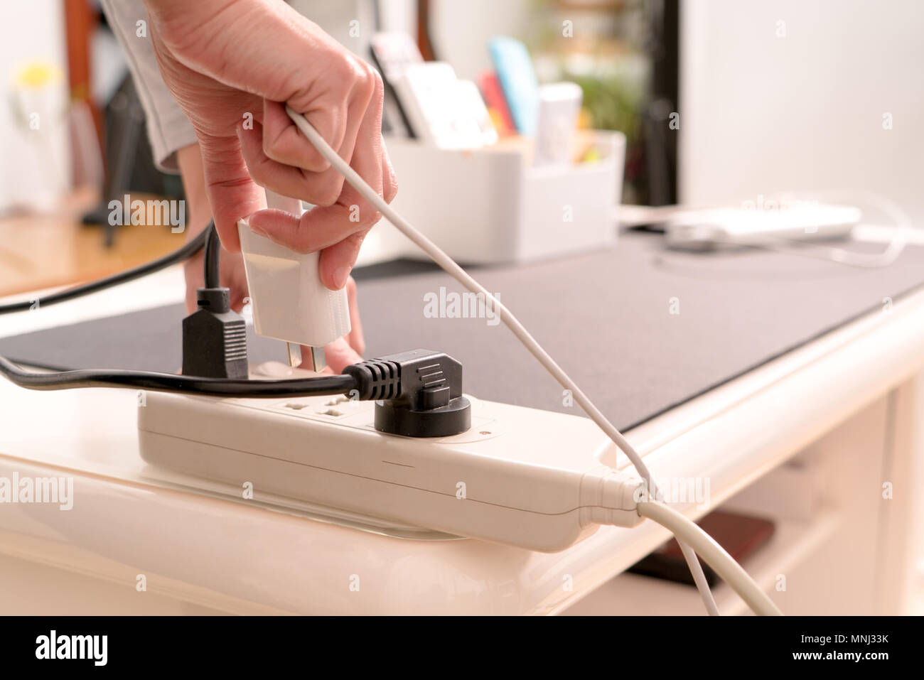 Frauen Hand halten Sie den Stecker der Stromversorgung Anschluss Stockfoto