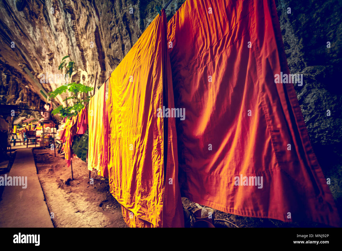 Der buddhistische Mönch Wäschetrockner auf dem Seil in der Höhle. Traditionelle orange und Safran Roben als Symbol des Buddhismus. Einer der heiligen Ort der Tha Stockfoto