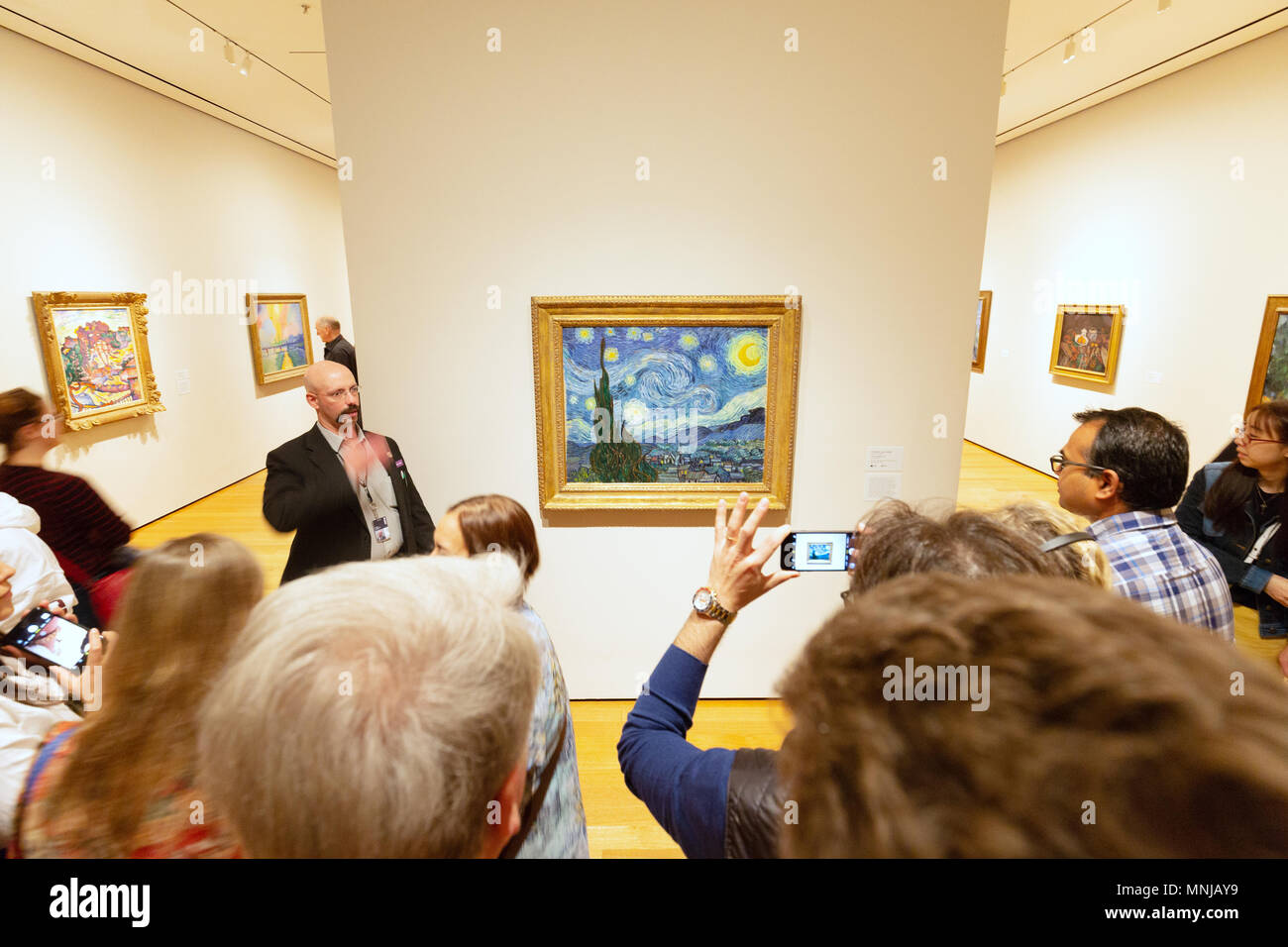 MoMA - Museum of Modern Art New York Innenraum - Menschen auf der Suche nach ' Öl Malerei der sternenklaren Nacht' von Vincent Van Gogh, MoMA, New York City, USA Stockfoto
