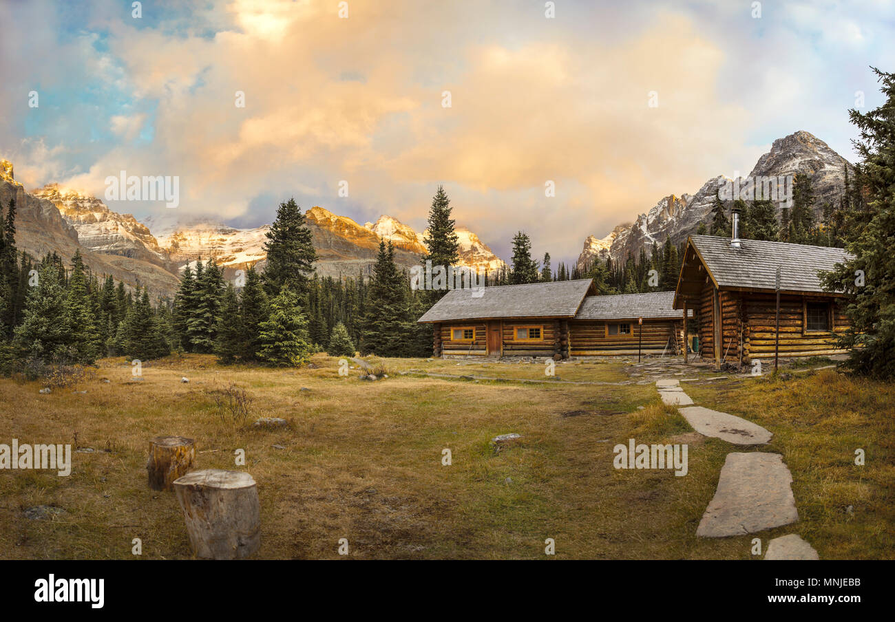 Anzeigen von Hütten und Berge im Hintergrund Anmelden bei Sonnenuntergang, Feld, British Columbia, Kanada Stockfoto