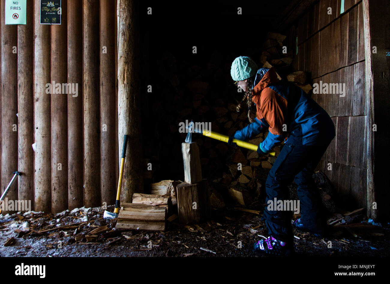 Frau hackt Holz mit Ax außerhalb backcountry Hütte in der Nähe von Mount Hood, Oregon, USA Stockfoto
