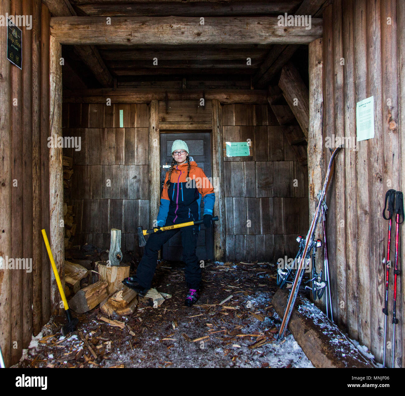 Frau hackt Holz mit Ax außerhalb backcountry Hütte in der Nähe von Mount Hood, Oregon, USA Stockfoto