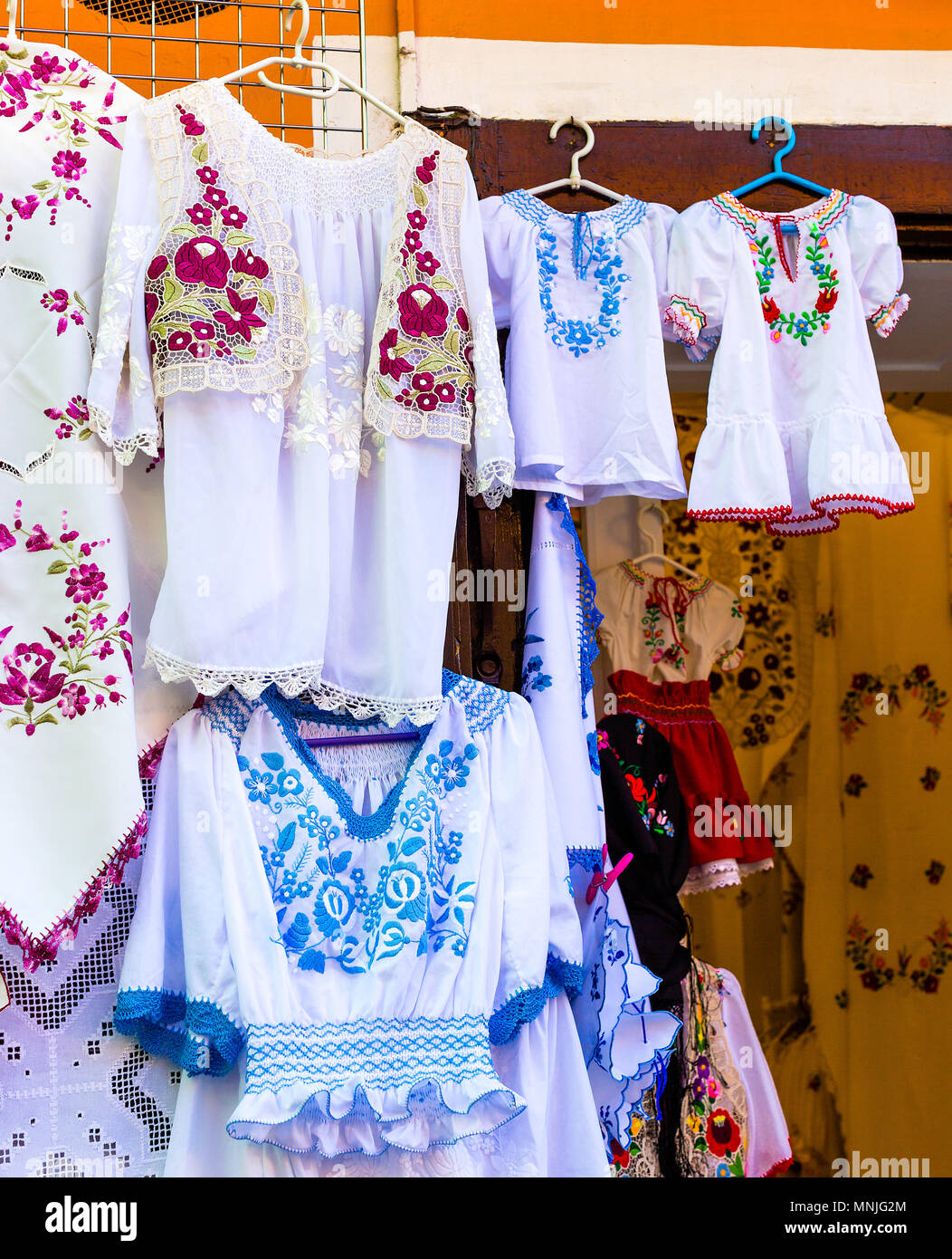Schönes helles ethnischen Shirts und Tischdecken mit traditionellen ungarischen Stickerei in einer Straße zu speichern. Vertikale Foto Stockfoto