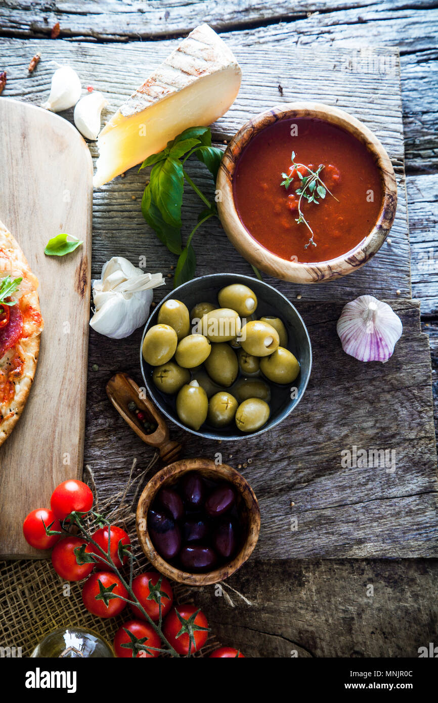 Frische italienische Pizza Zutaten auf Holz. Pizza mit Käse, Salami und Tomaten. Fast food. Rustikale pizza Stockfoto