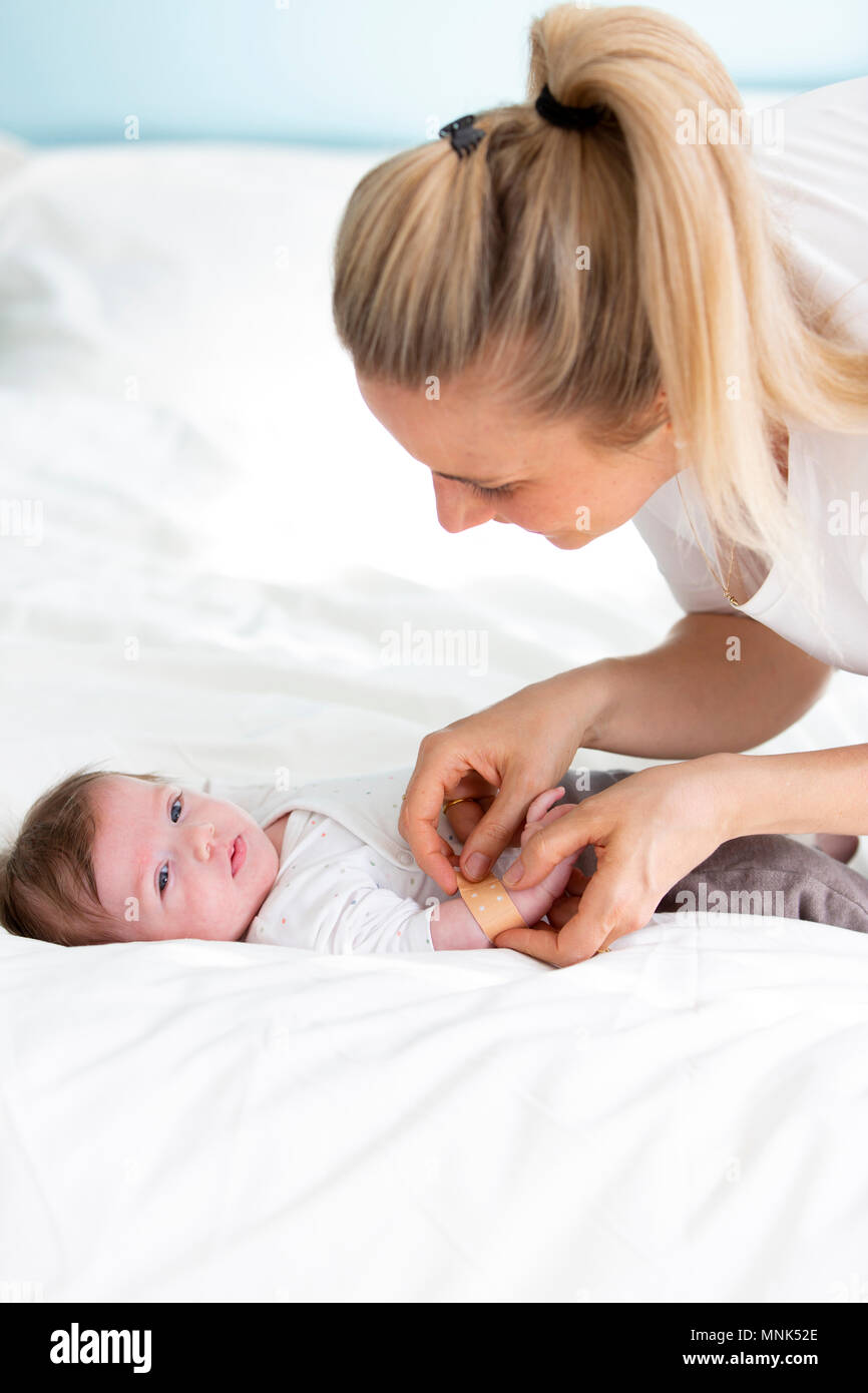 Die Mutter oder der Arzt oder die Krankenschwester setzt ein Pflaster auf  der Baby hand Stockfotografie - Alamy