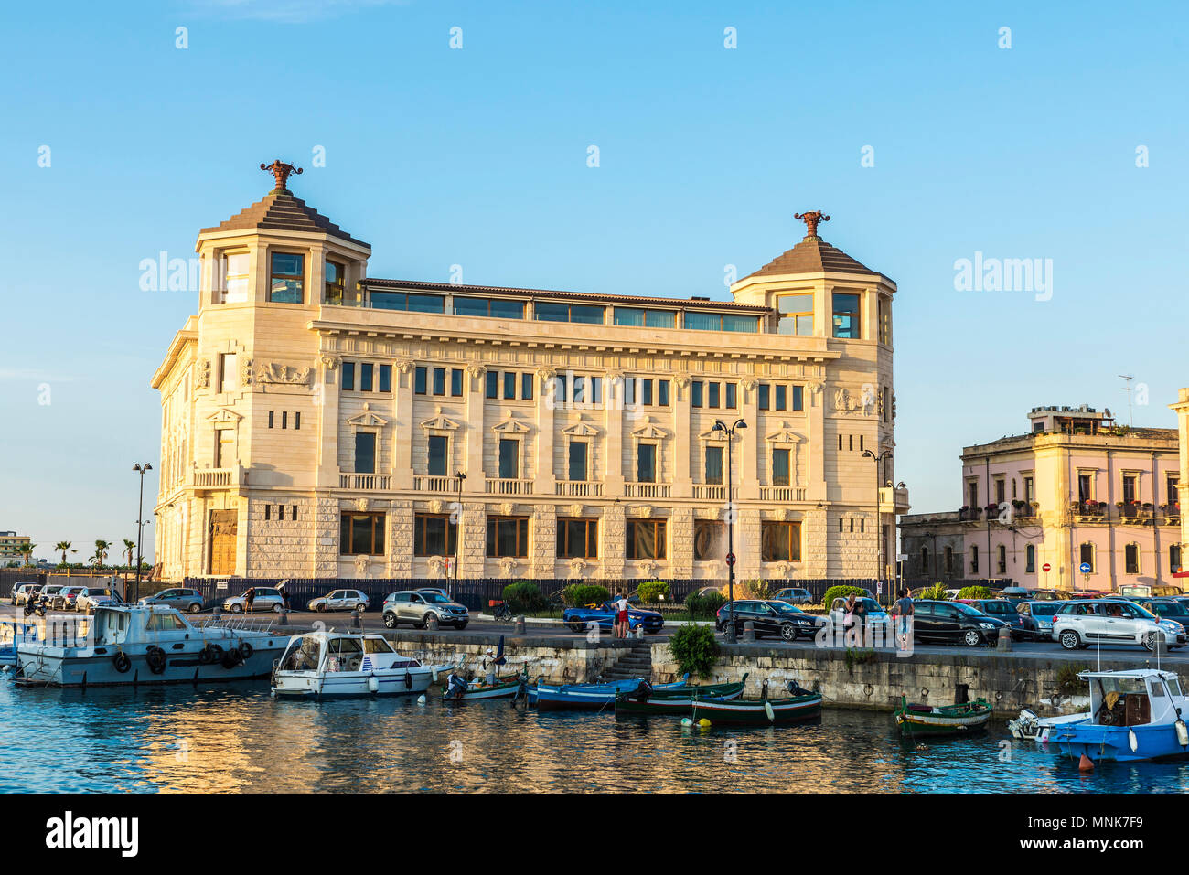 Angeln und Freizeit Boote an der Marina mit klassischen Gebäuden und Menschen um in der historischen Stadt Syrakus in Sizilien, Italien angedockt Stockfoto