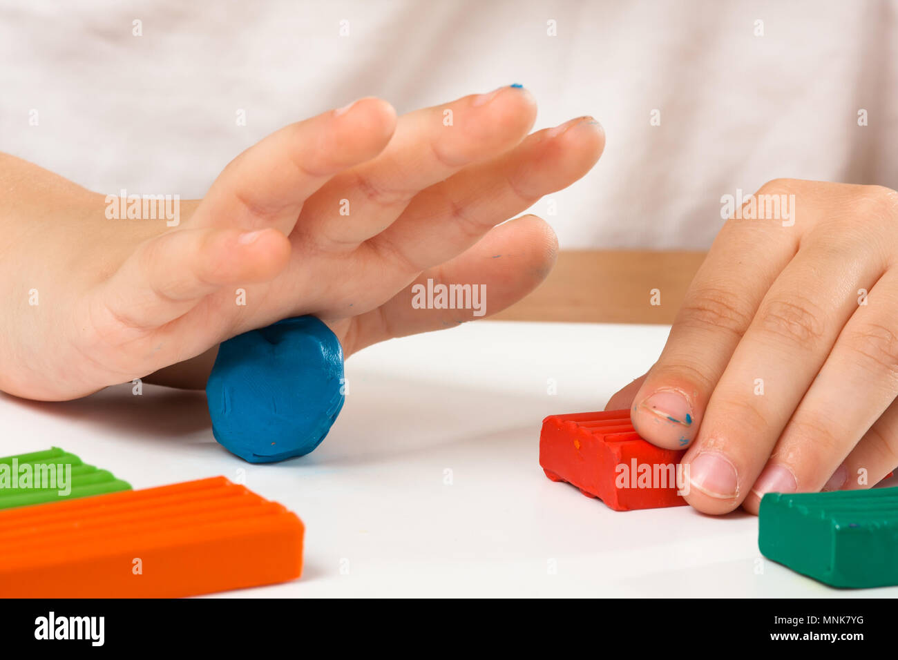 Kind Hände Formteil aus Knetmasse auf den Tisch Stockfoto