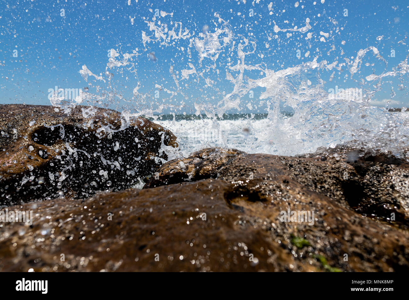 Wasser, Felsen an einem Strand in der Nähe von Sotogrande an der Costa del Sol in Spanien. Stockfoto