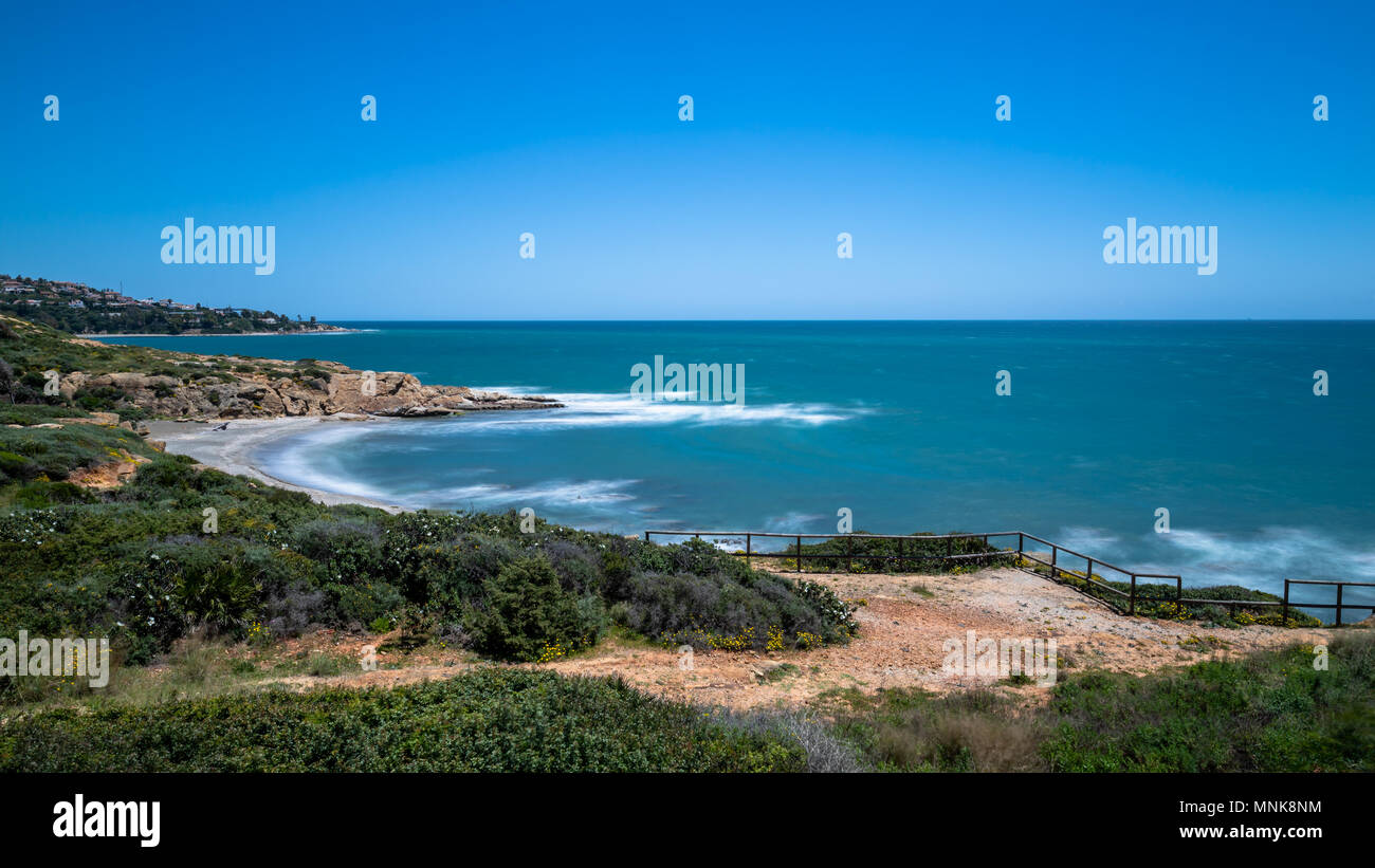 Wasser, Felsen an einem Strand in der Nähe von Sotogrande an der Costa del Sol in Spanien. Stockfoto