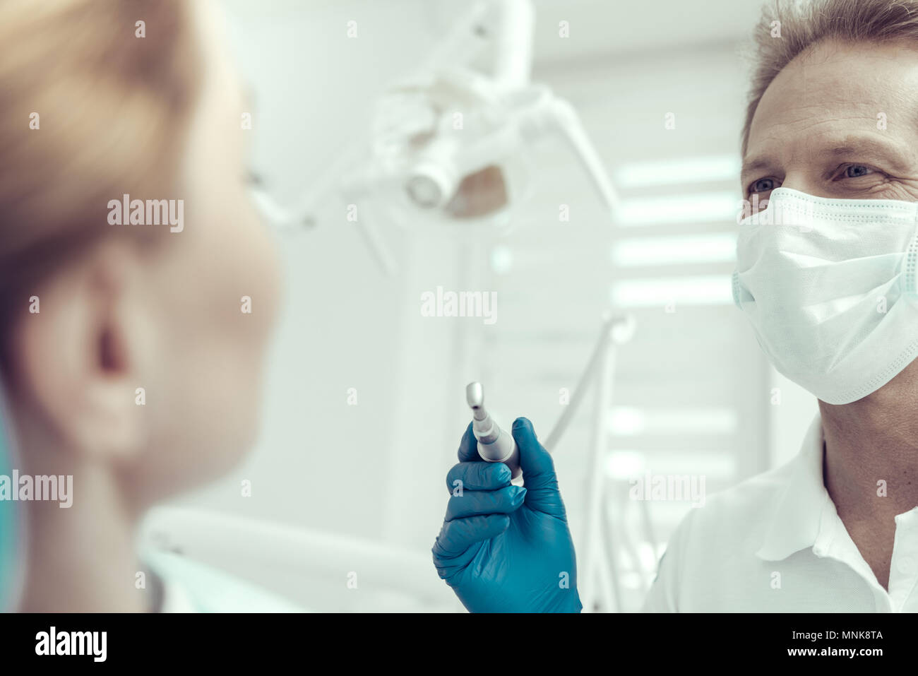 Freundlich Zahnarzt bei seinem Patienten, die vor der Durchführung des Verfahrens Stockfoto