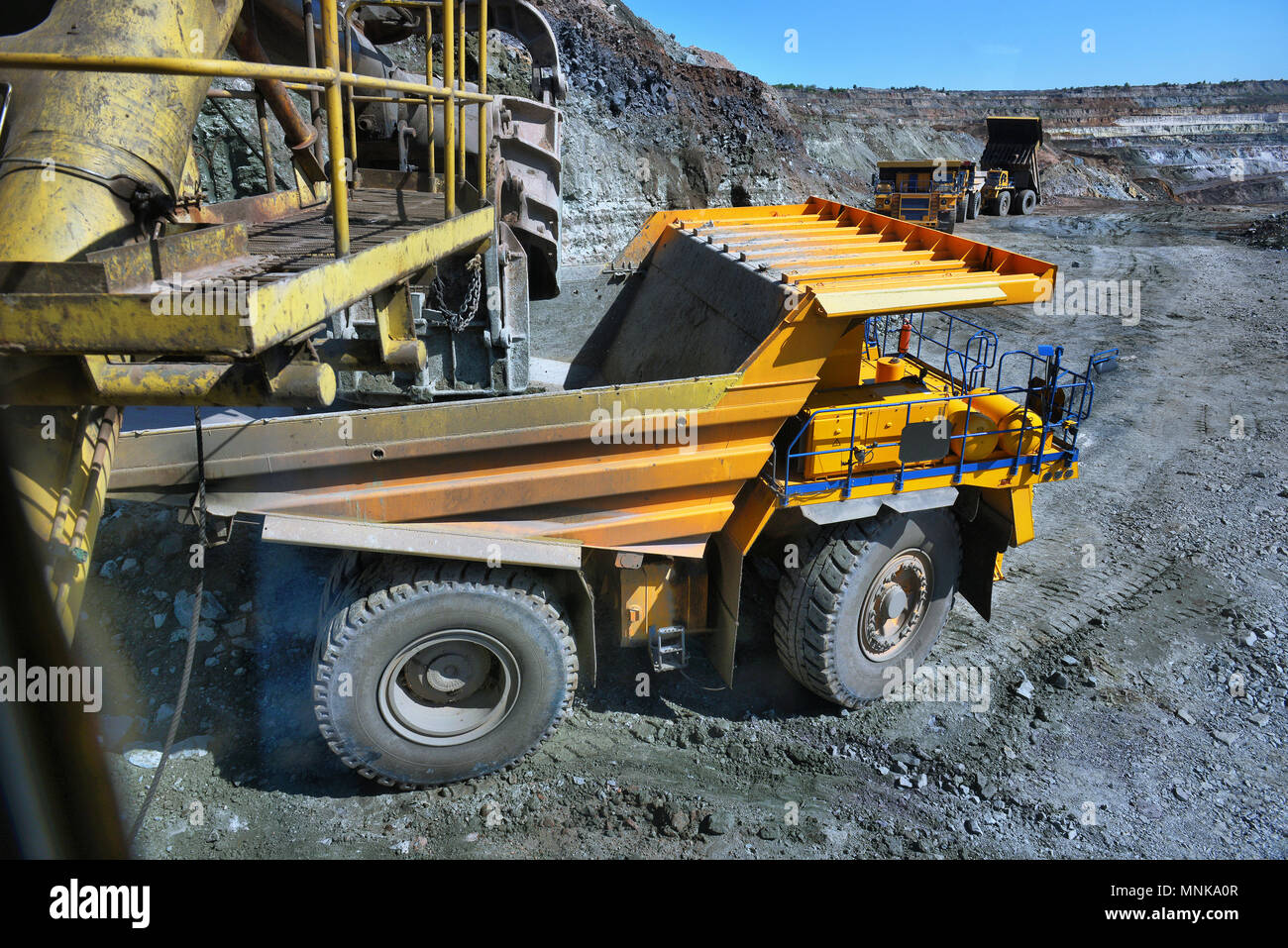 Großen Steinbruch Dump Truck. Laden der Felsen in die Mulde. Laden von Kohle in Body work Truck. Mining Truck Bergbaumaschinen, Kohle vom offenen zum Transport Stockfoto