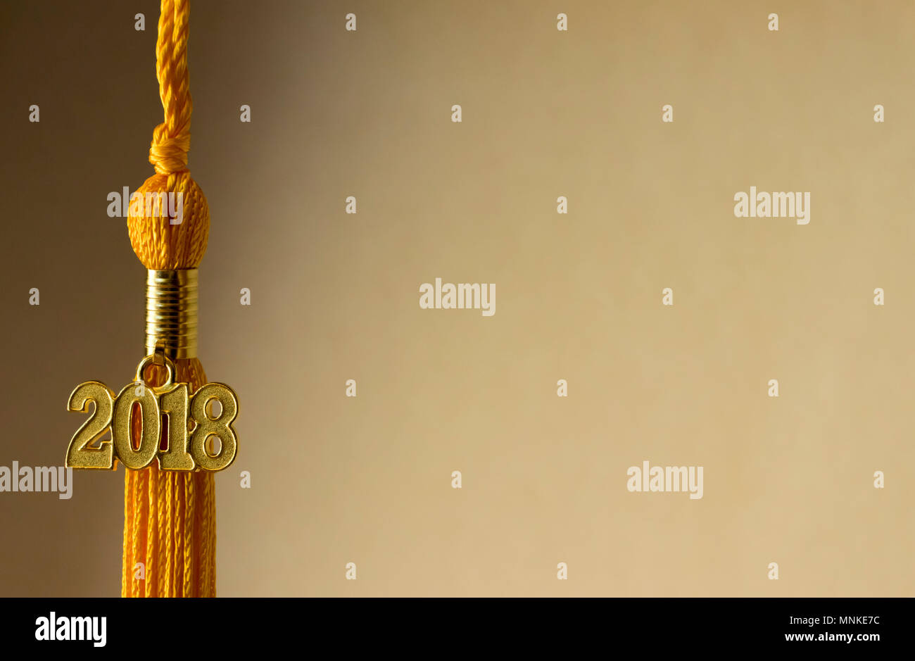 Klasse von 2018. Gold Quaste drop Graduierung kleid Zubehör und Andenken Charme mit seitlicher Beleuchtung. Iconic Symbol des graduierten wissenschaftlichen Erfolg. Stockfoto