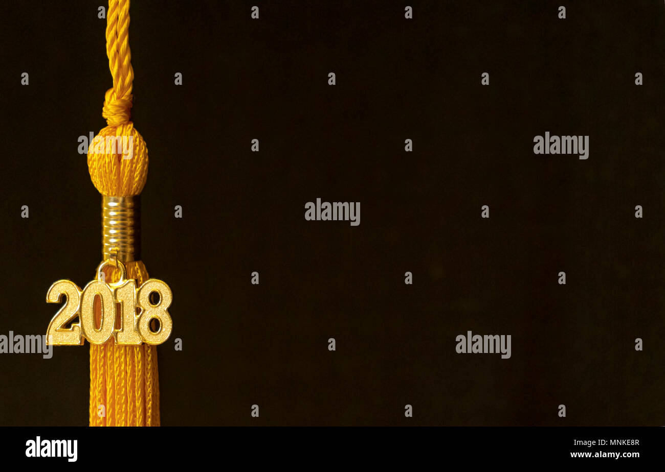 Klasse von 2018. Gold Quaste drop Graduierung kleid Zubehör und Andenken vor einem schwarzen Hintergrund. Iconic Symbol der Absolvent den akademischen Leistungen. Stockfoto