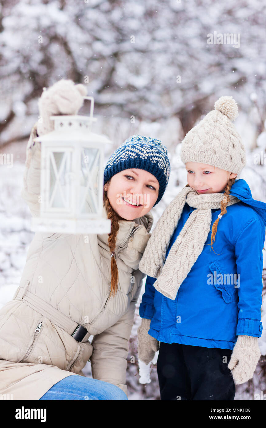 Familie von Mutter und ihre süßen kleinen Tochter mit Weihnachten Laterne im Freien auf der schönen winter schnee Tag Stockfoto