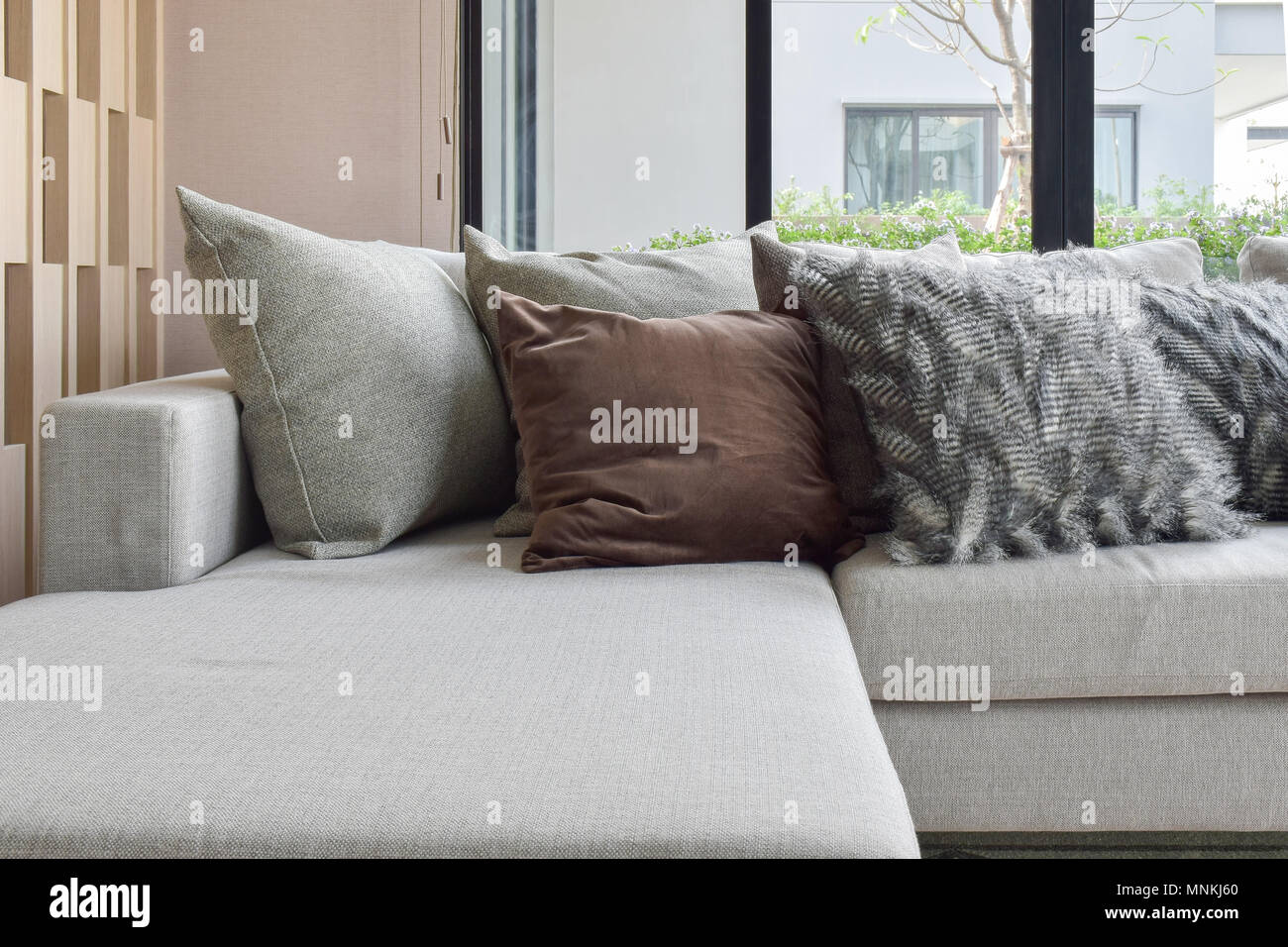 Braun und Grau Kissen Einstellung auf beige Couch in der Ecke der  Wohnzimmer Stockfotografie - Alamy