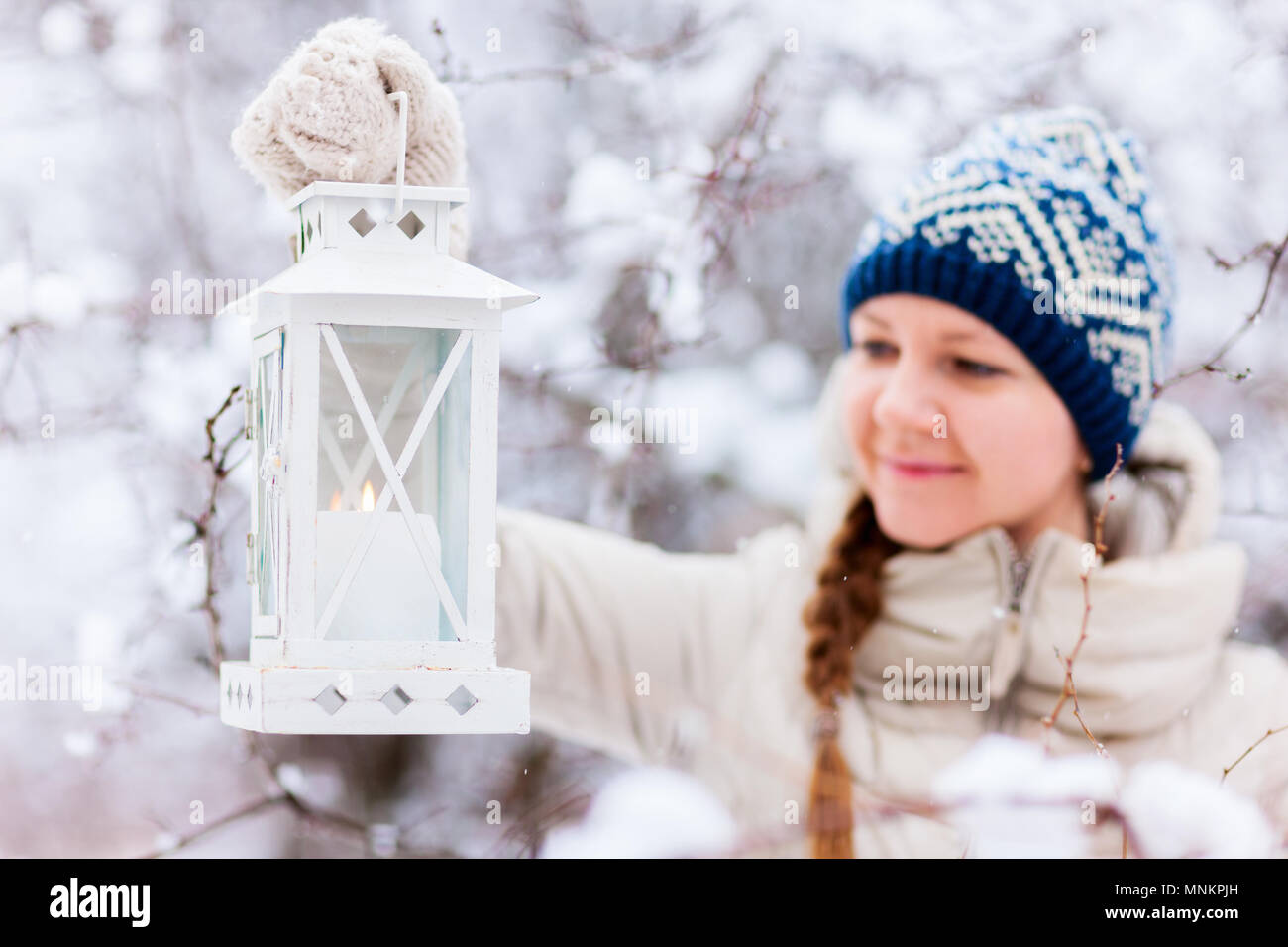 Junge Frau mit Weihnachten Laterne im Freien an schönen Wintertag im Schnee Stockfoto