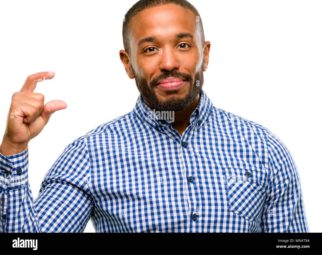 Afrikanische amerikanische Mann mit Bart Holding etwas sehr winzig, Größe Konzept auf weißem Hintergrund Stockfoto