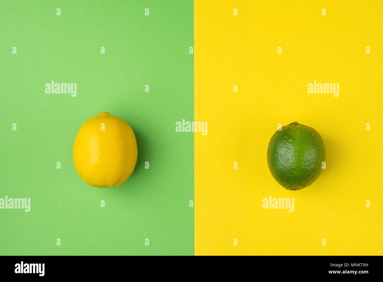 Reif Bio Zitrone und Limette auf Split Duplex Grün gelben Hintergrund. Kreative Bild gestaltet. Zitrusfrüchte Vitamine Sommer vegane Fashion Concept. Essen Stockfoto