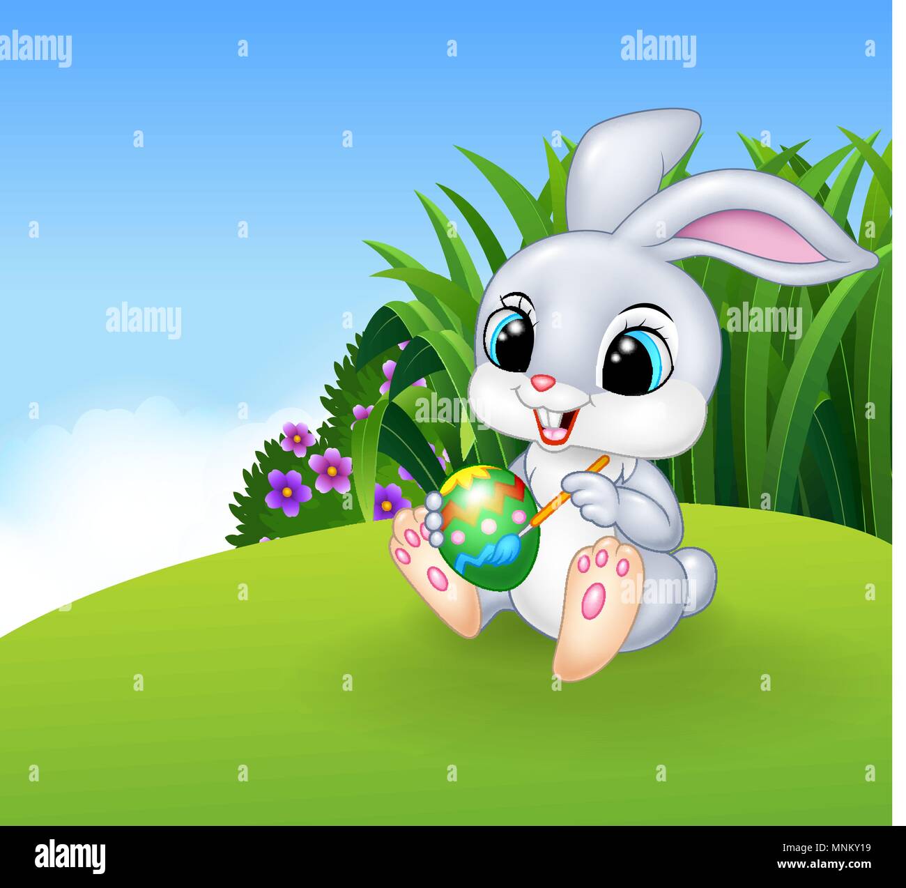 Niedliche Osterhasen malen ein Ei auf der Wiese-Hintergrund Stock