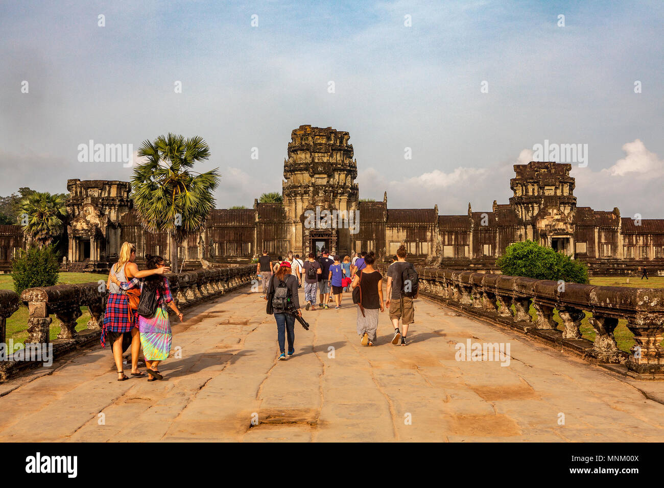 Touristen aus verschiedenen Ländern zu Fuß den Sandstein block Straße auf ihren Ansatz der äußeren Wand Verlassen der Tempelanlage Angkor Wat, Siem Reap, Cambodi Stockfoto