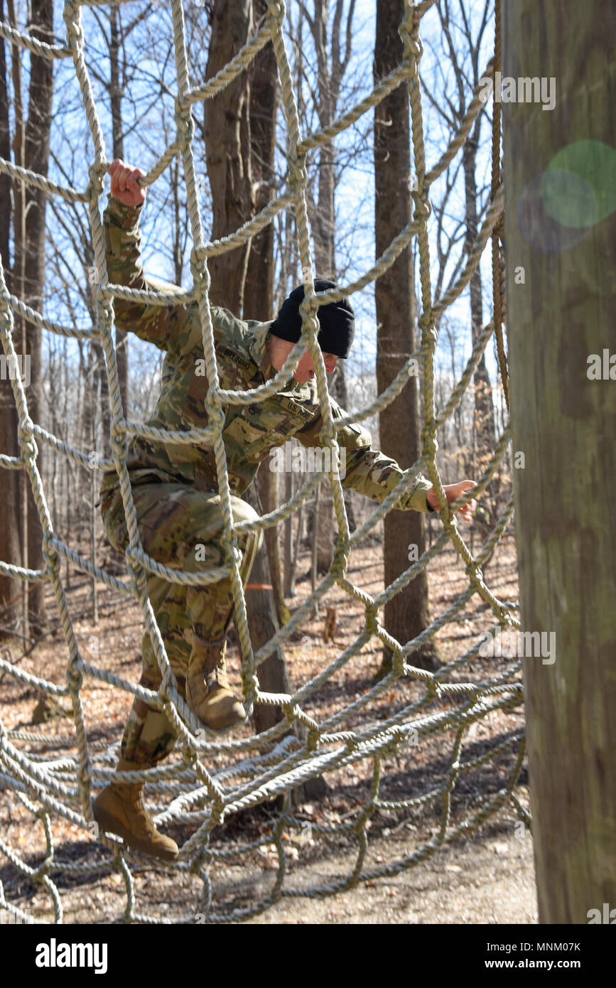 Pfc. Joseph Breining, 115 MP Mrd., das Netz während den Hindernislauf Teil der besten Maryland National Guard Warrior Wettbewerb steigt am 16. März 2018, Schießpulver militärischen Reservierung, Glen Arm, Maryland. Service für Mitglieder von der Maryland Armee und Air National Guard, sowie die staatlichen Partner Nationen von Bosnien-herzegowina und Estland, wetteifern um die besten Krieger Titel 2018 Der während der Maryland National Guard Warrior Wettbewerb. Wettbewerber bestehen eine Vielzahl von Krieger Aufgaben sich zu beweisen, die Besten der Besten. Der Wettbewerb ist ein mehrtägiger Marathon der geistigen Ein Stockfoto