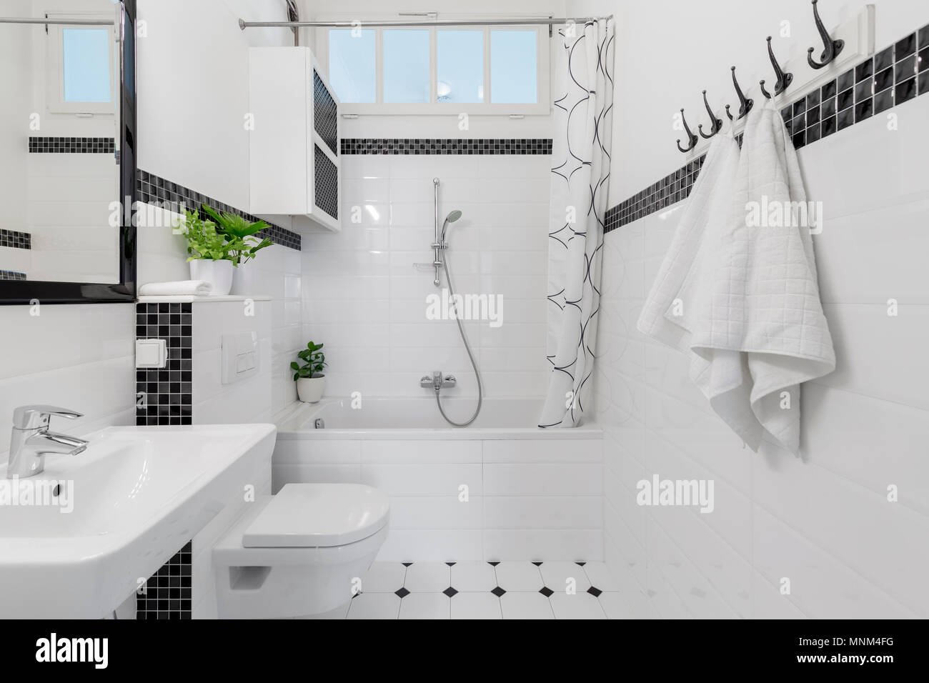 Handtücher und Spiegel in Weiß und Schwarz Bad mit Badewanne und Toilette.  Real Photo Stockfotografie - Alamy