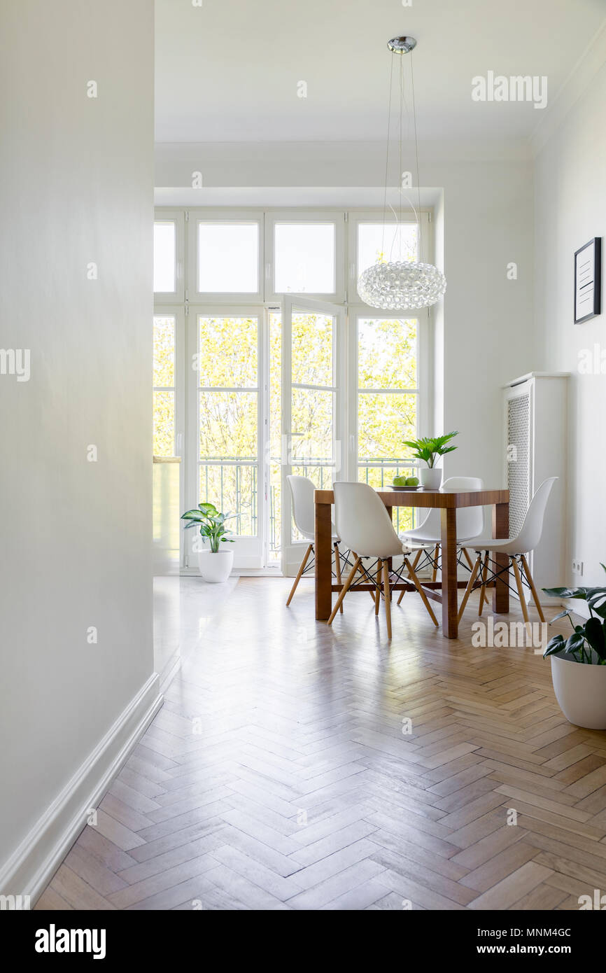 Weißen Stühlen an den hölzernen Tisch im großen Speisesaal Innenraum mit Fenster. Real Photo Stockfoto