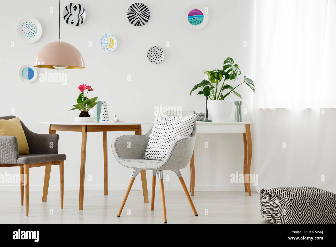 Retro Sessel, Tisch, Kronleuchter, keramische Wand Dekoration und Puff in einem hellen Wohnung Interieur Stockfoto