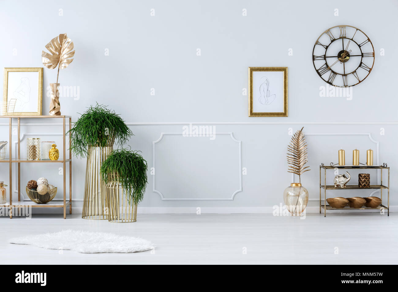Goldenen Dekorationen im Vorraum Interieur mit Pflanzen, Metall Uhr an der Wand und Wand spritzgießen Stockfoto