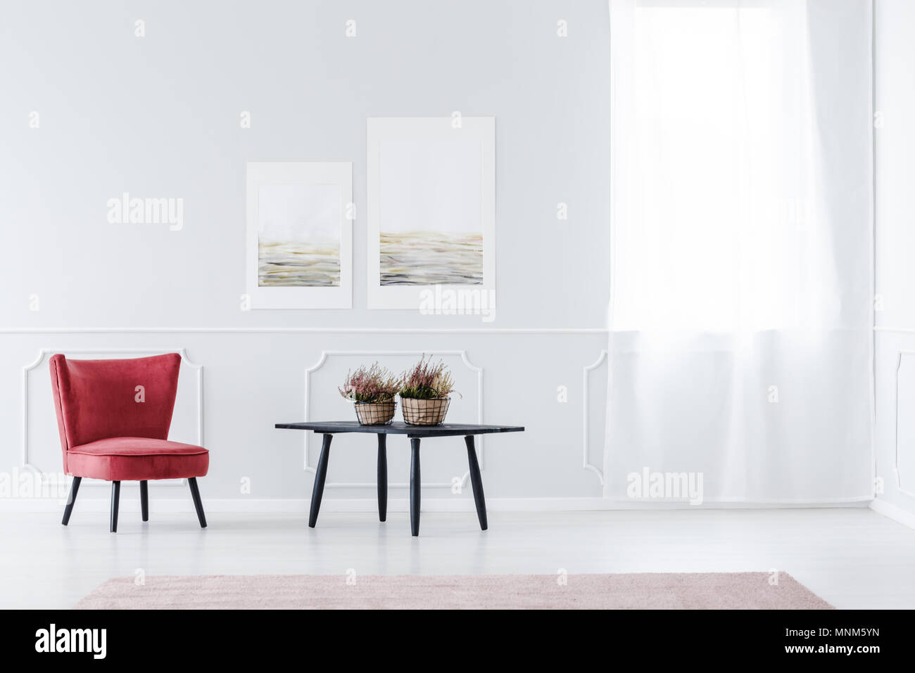 Rot, Samt Sessel im hellen Wohnzimmer Einrichtung mit schwarzen Tisch und Wand mit Spritzguss Stockfoto