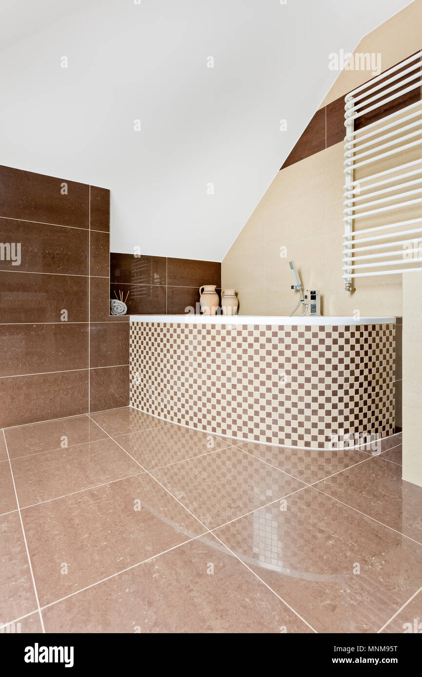 Modernes Bad mit braunen Fliesen und Mosaik Fliesen Badewanne Stockfoto