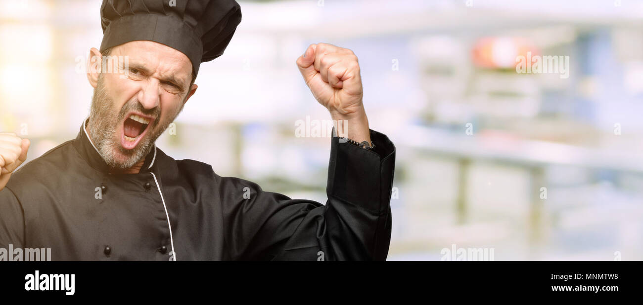 Senior cook Mann mit Küchenchef hat glücklich und aufgeregt feiert Sieg zum Ausdruck großer Erfolg, Leistung, Energie und positive Emotionen. Feiert neuen Jo Stockfoto