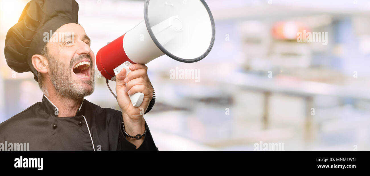 Senior Chef kochen Mann mit Hut kommuniziert schreien laut Holding ein Megaphon, mit dem Ausdruck Erfolg und positive Konzept, Idee, Marketing oder Vertrieb Stockfoto
