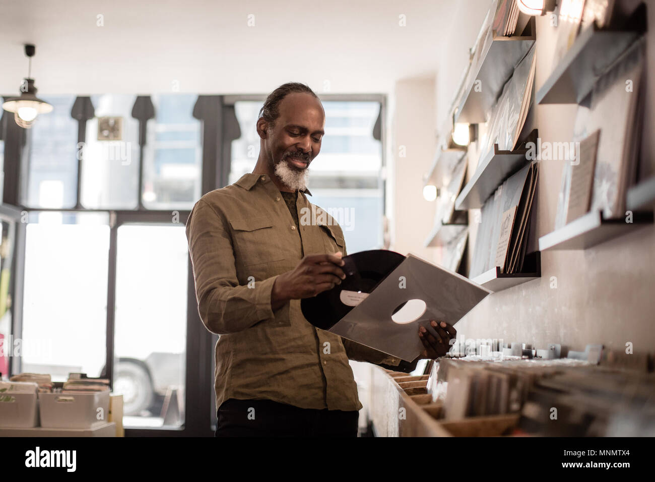 Ältere männliche Holding einen Datensatz in einem Store Stockfoto