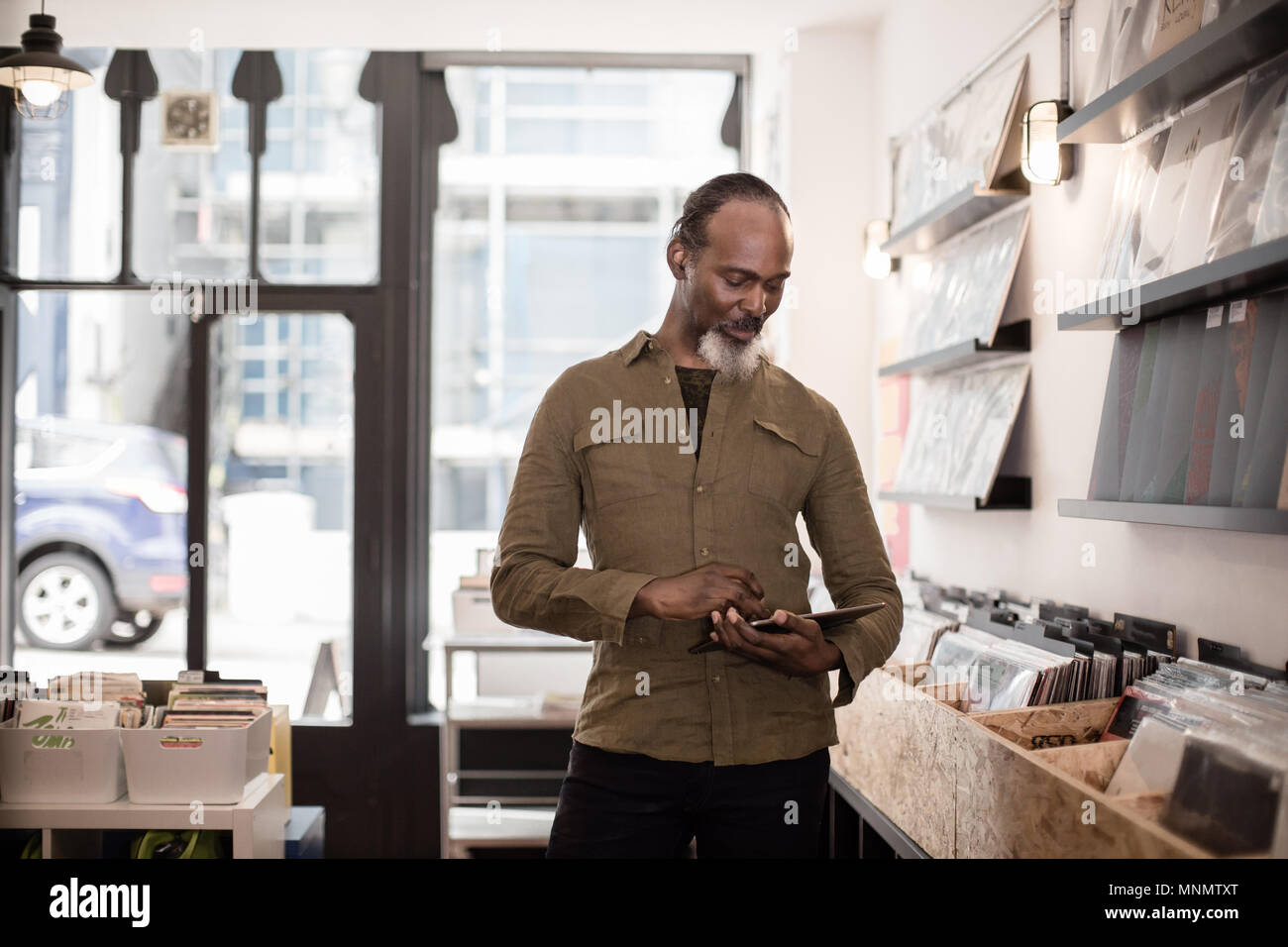 Inhaber kleiner Unternehmen mit digitalen Tablet in einem Plattenladen Stockfoto