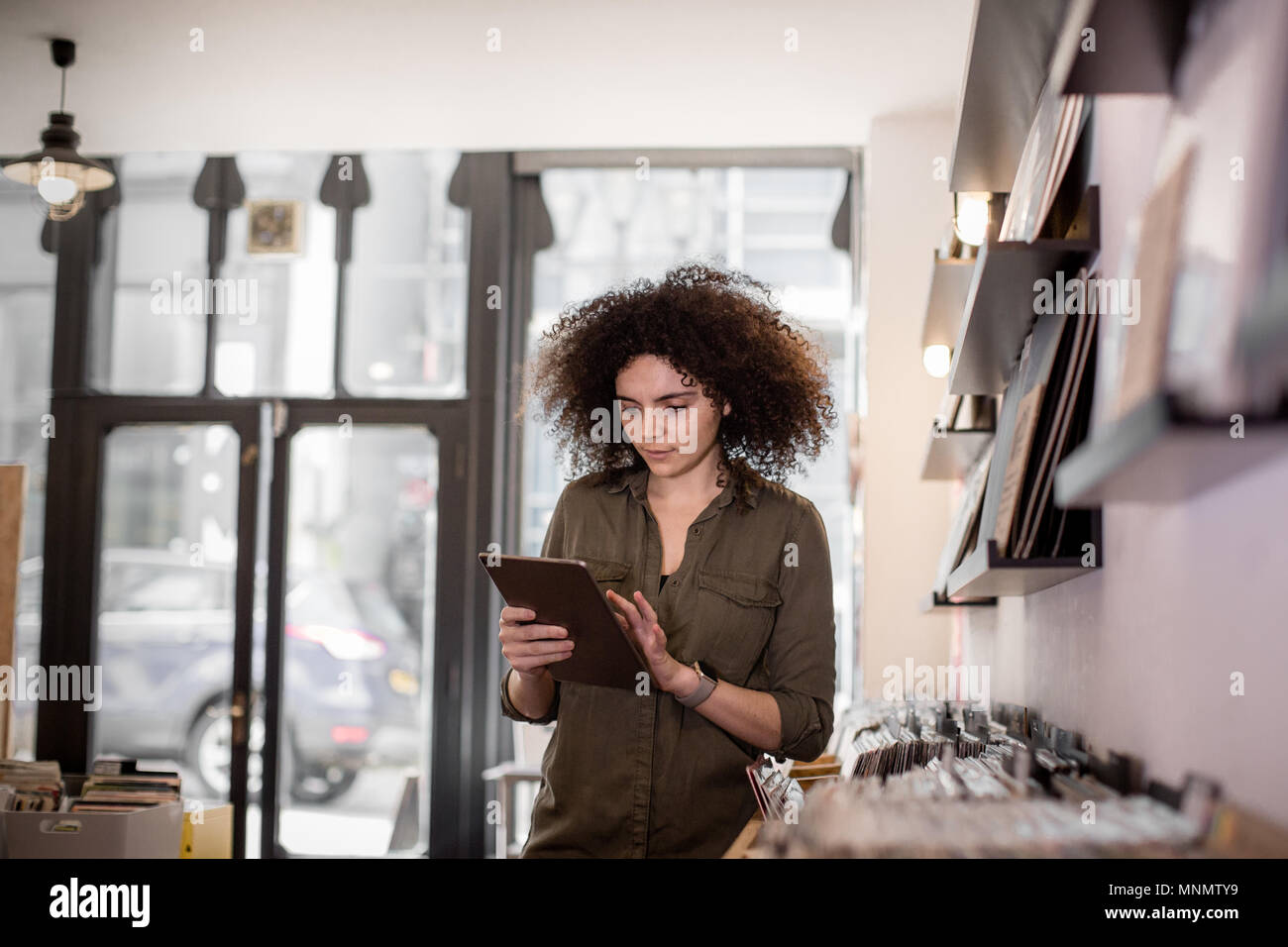 Inhaber kleiner Unternehmen mit digitalen Tablet in einem Plattenladen Stockfoto