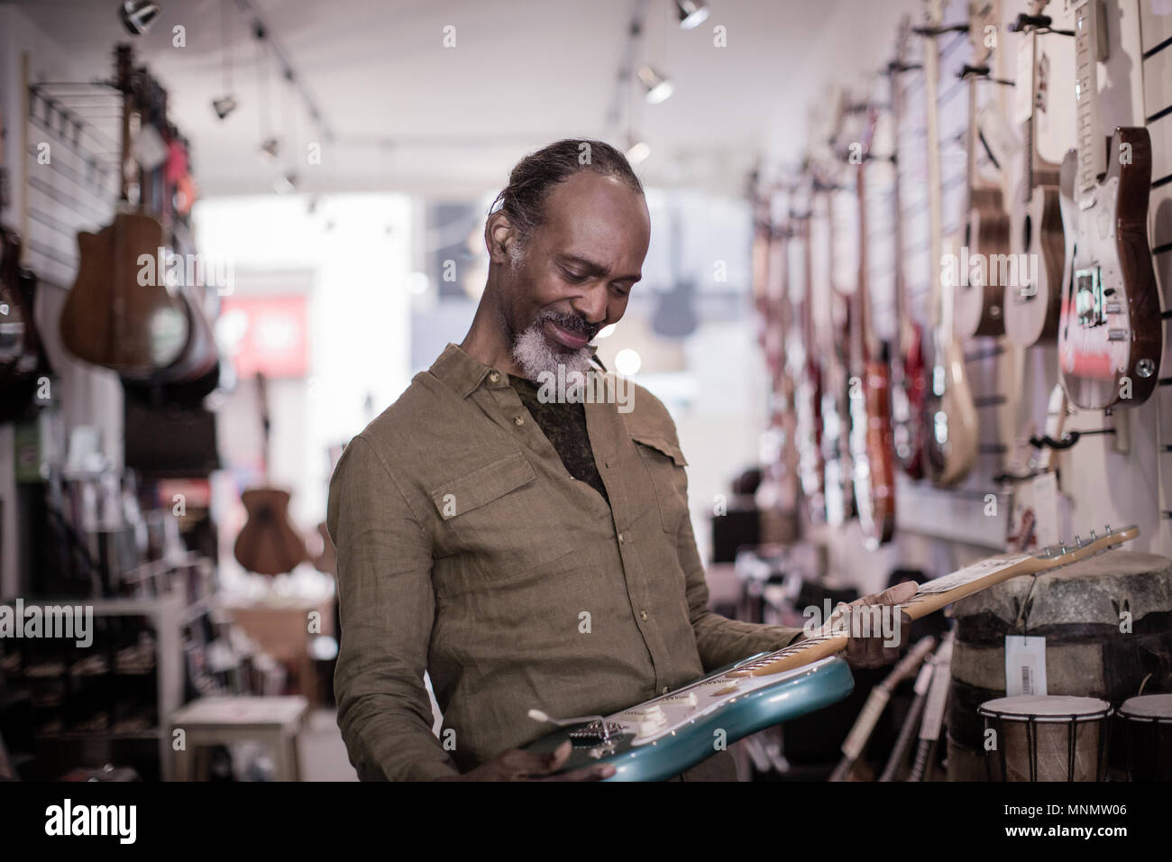 Ältere männliche Einkaufen in einem Guitar Store Stockfoto