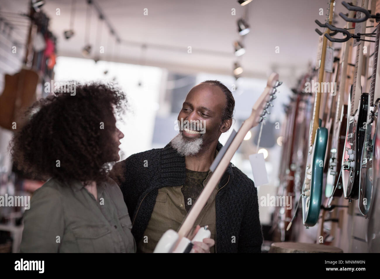 Inhaber kleiner Unternehmen hilft Kunden in einem Guitar Store Stockfoto