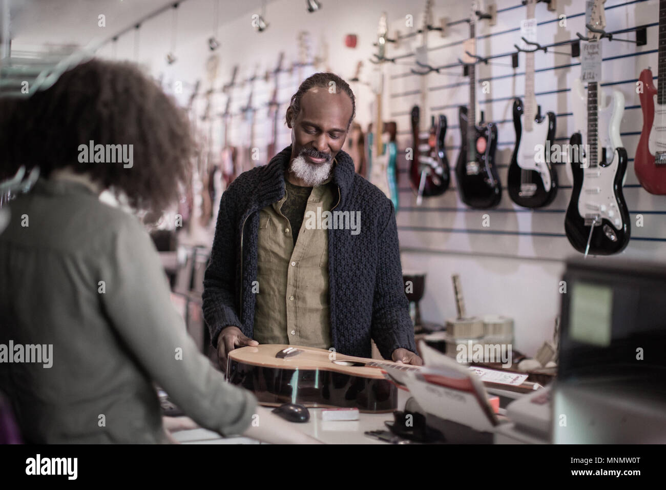Ältere männliche Kauf eine akustische Gitarre. Stockfoto