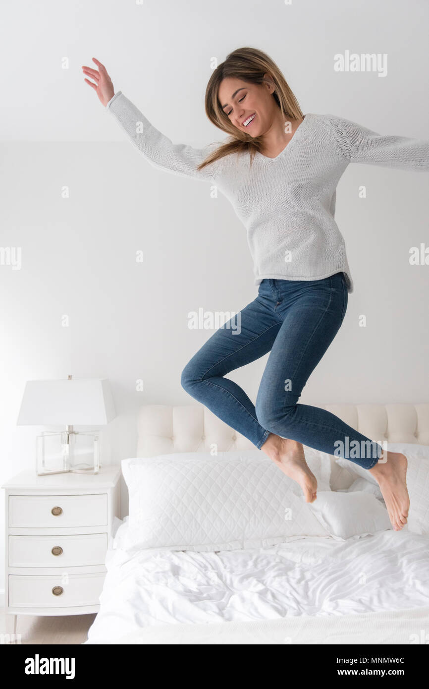 Junge Frau im Schlafzimmer springen Stockfoto