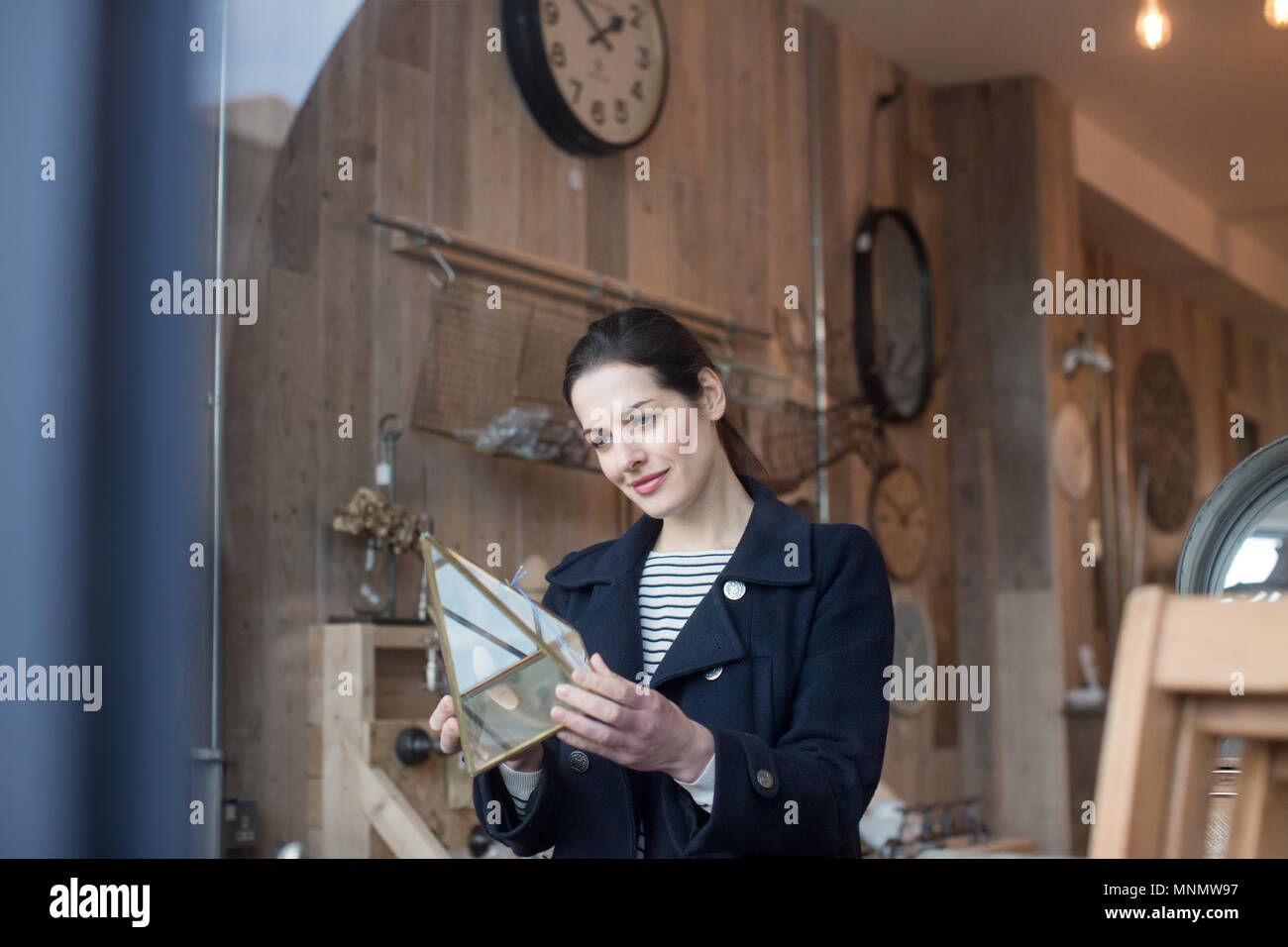 Erwachsene Frau Einkaufen in einem Vintage antiken Speicher Stockfoto