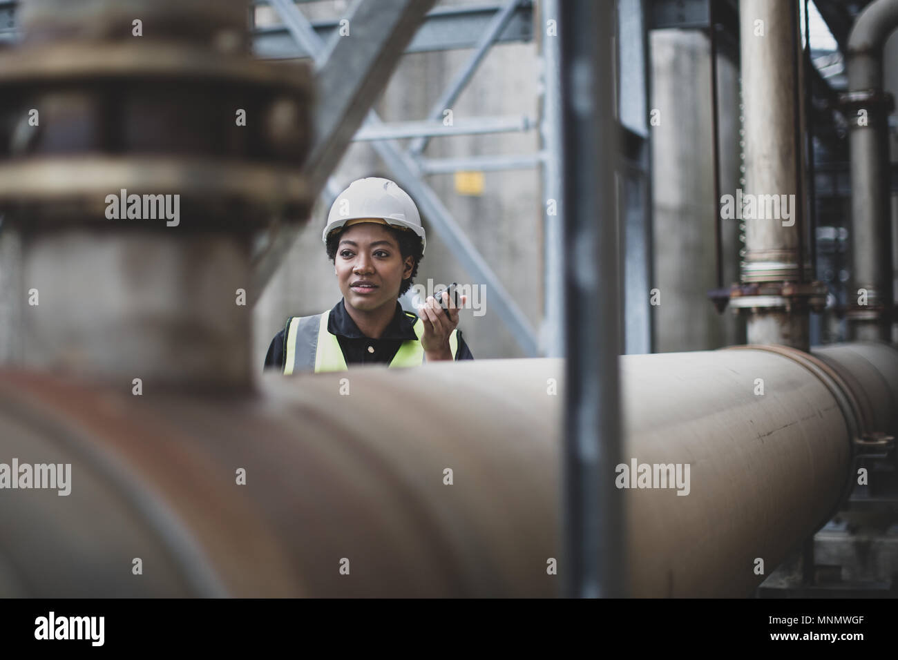 Weibliche Industriearbeiter mit Radio vor Ort Stockfoto