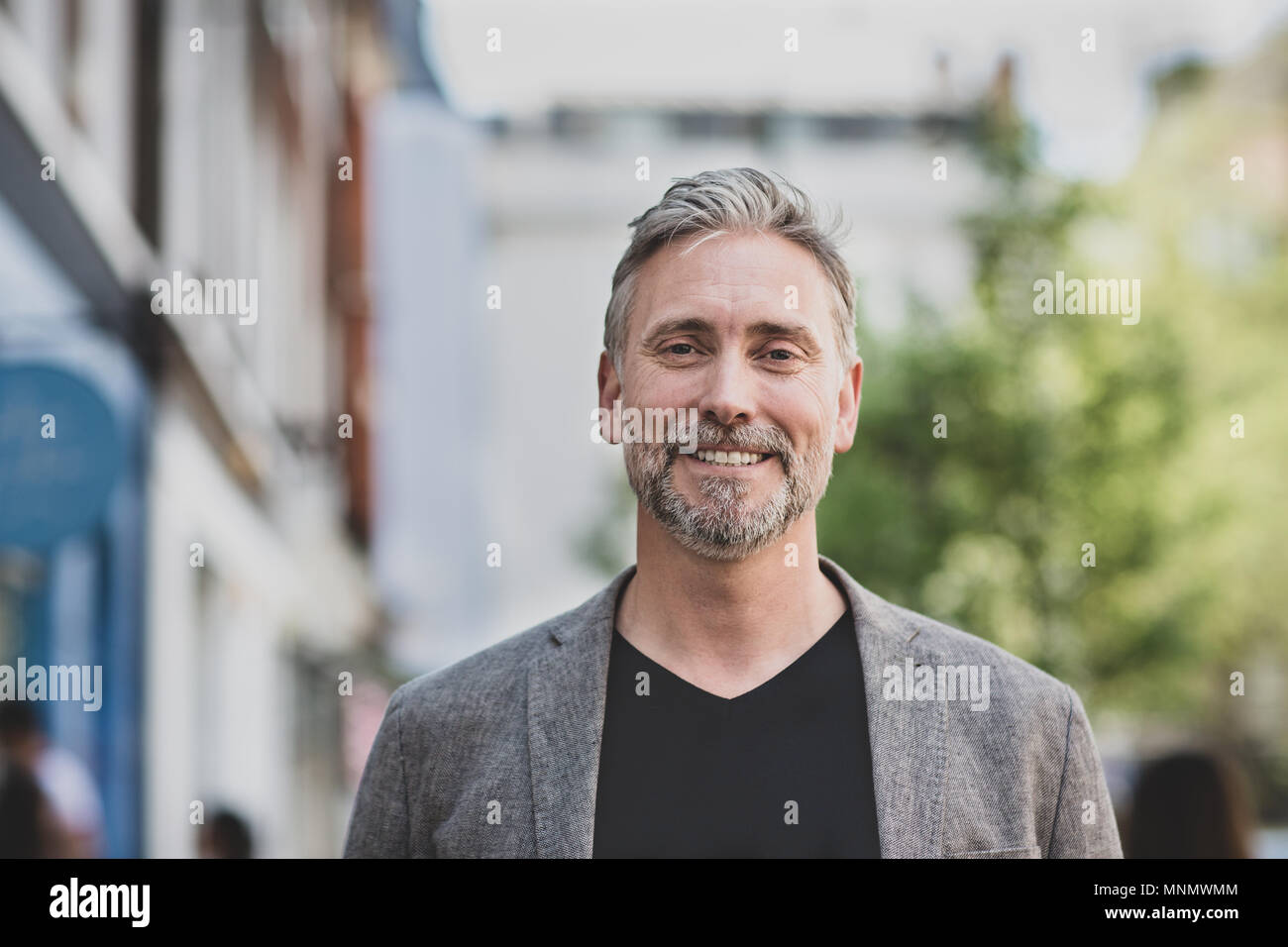 Portrait von lächelnden reifer Mann draußen in der Stadt Stockfoto