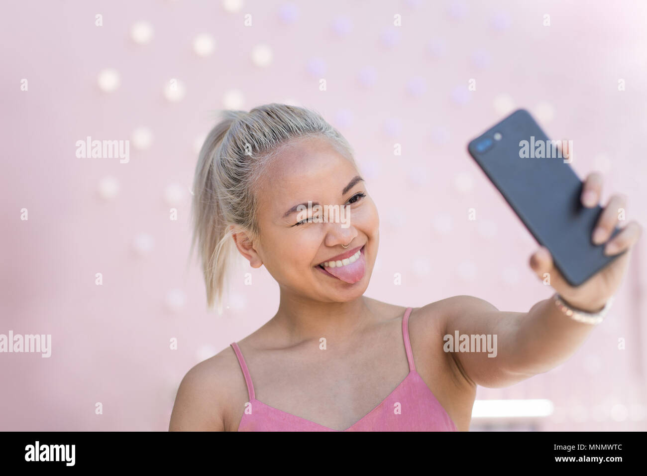 Junge Erwachsene weiblichen unter selfie mit rosa Hintergrund Stockfoto