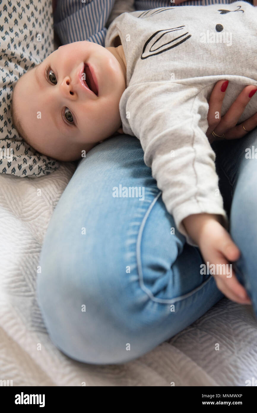 Baby Girl (12-17 Monate) liegend auf Mama's Schoß Stockfoto