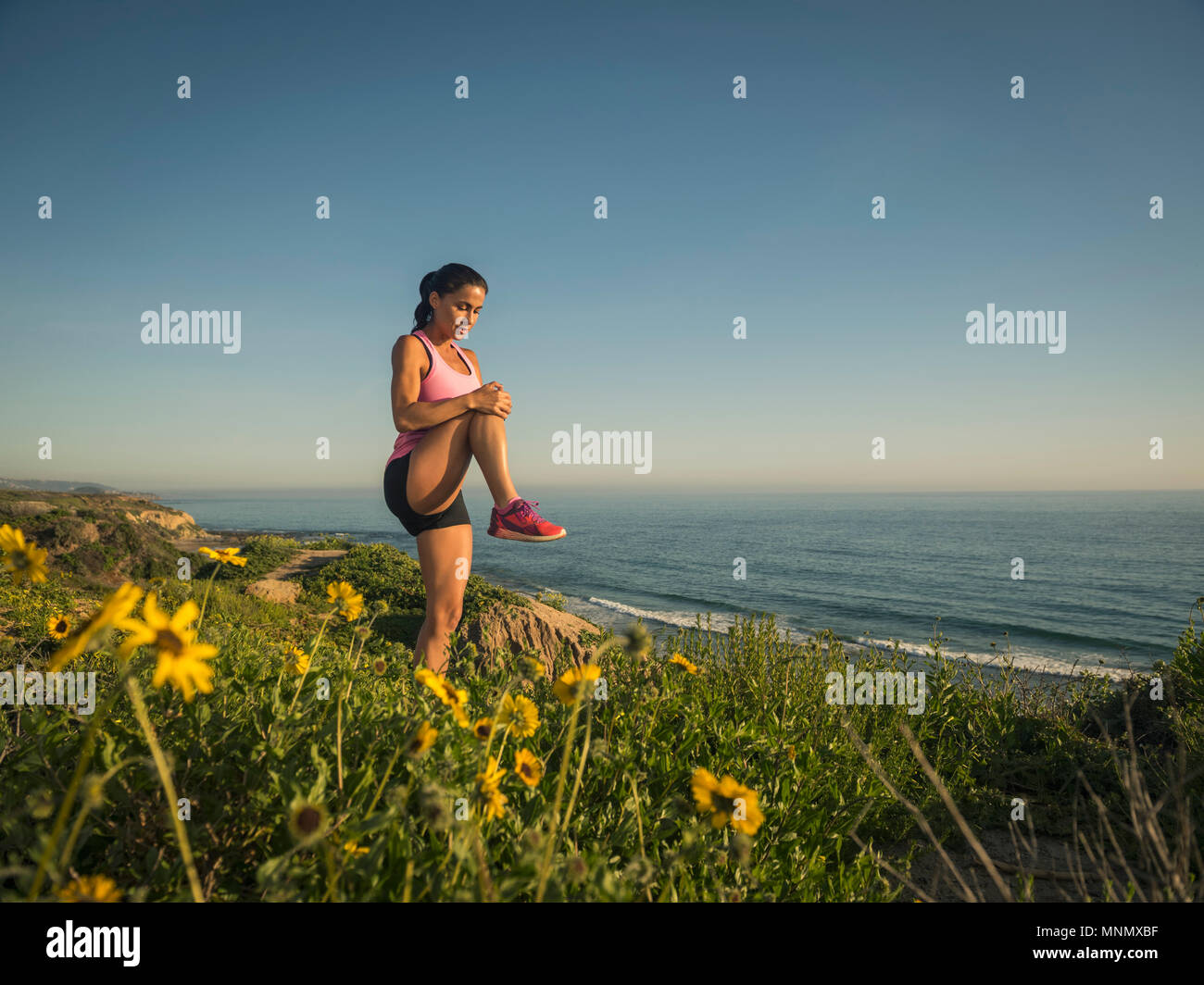USA, Kalifornien, Newport Beach, Frau stretching auf Klippe Stockfoto