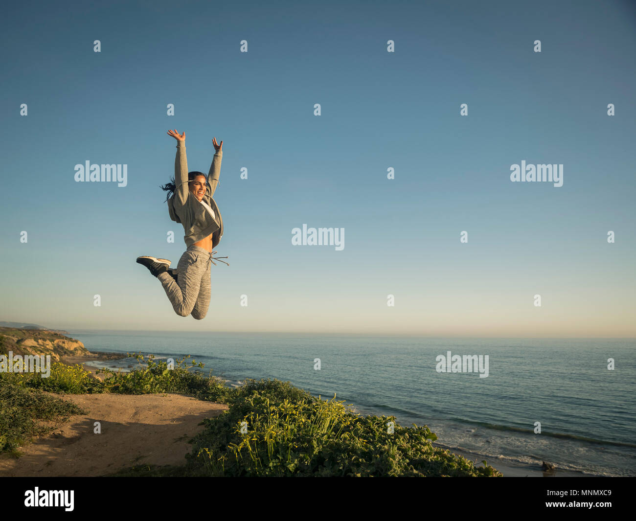 USA, Kalifornien, Newport Beach, Frau gegen den klaren Himmel springen Stockfoto