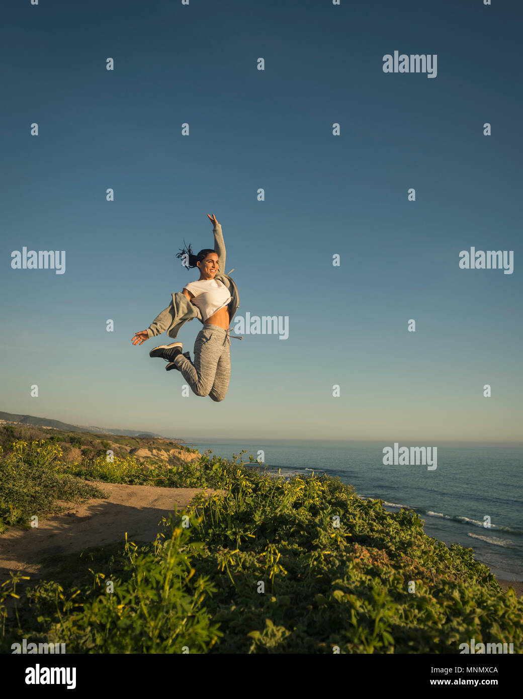 USA, Kalifornien, Newport Beach, Frau gegen den klaren Himmel springen Stockfoto