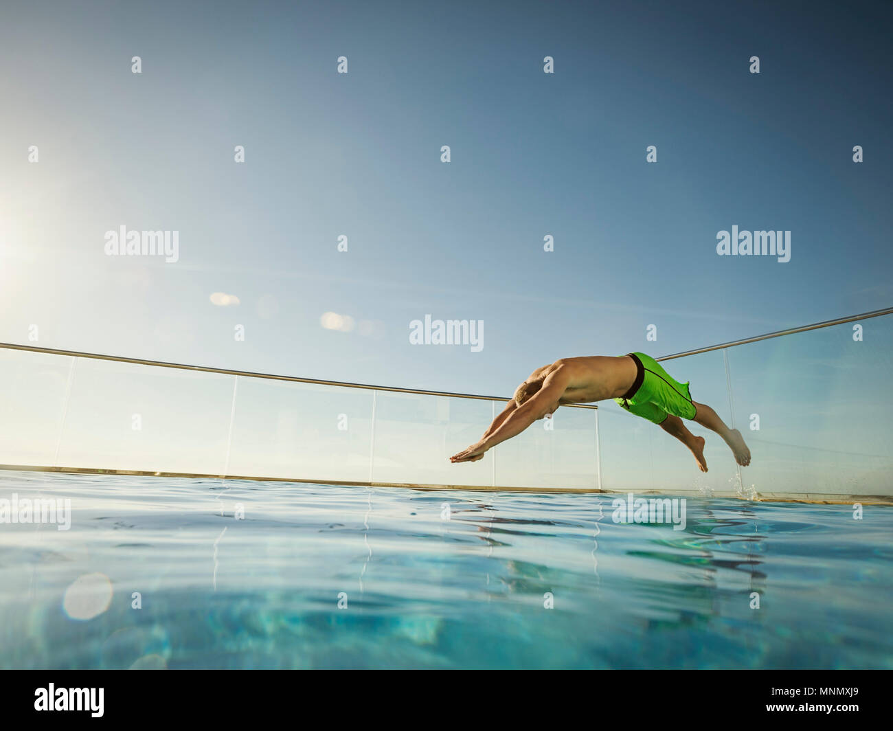 Mann springt in pool Stockfoto