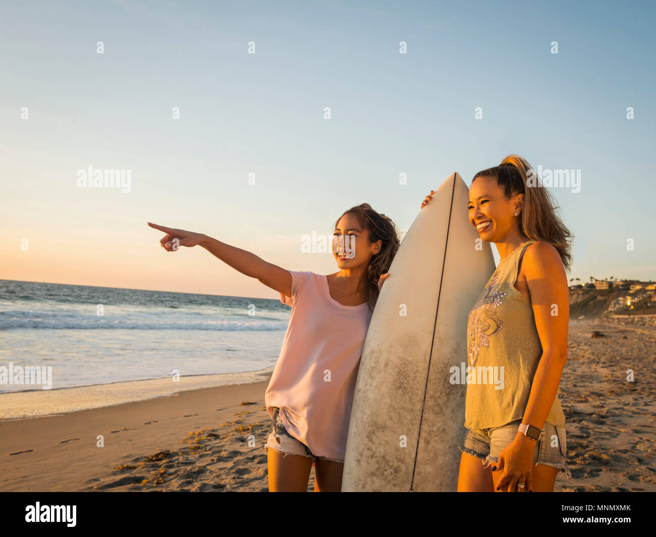 Mutter und Tochter mit Surfbrett Stockfoto